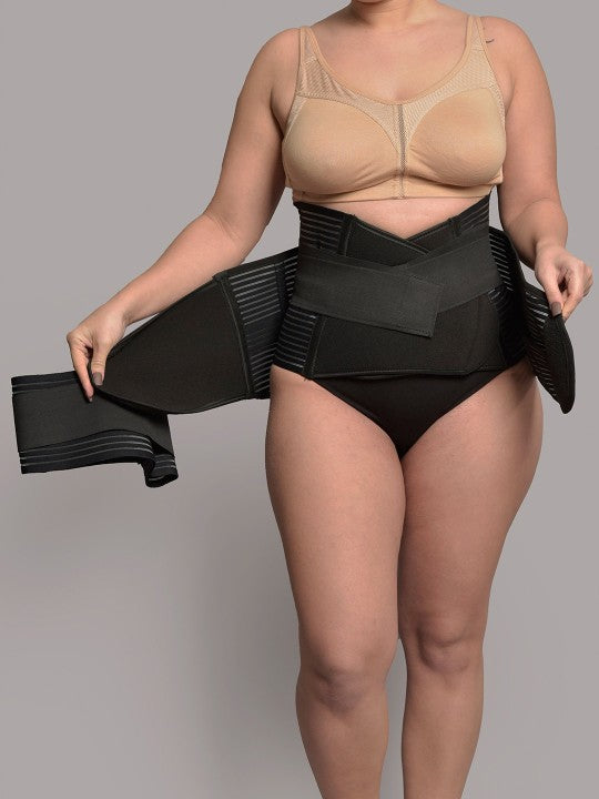 Woman wearing black 3-in-1 postnatal shapewear waist belt on grey background