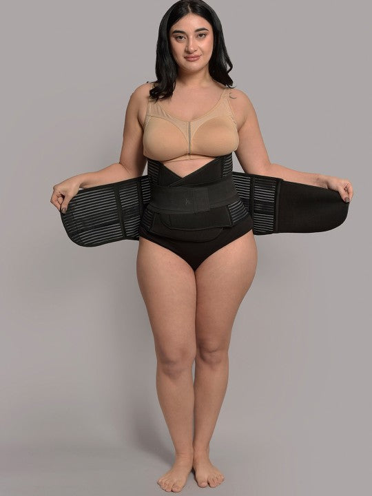 Woman modeling black 3-in-1 postnatal shapewear belt against plain background